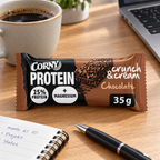 Stemningsillustration af Corny Protein Chocolate 35 g ved kaffe og notesbog