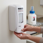 Illustreret udlevering af hvid håndlotion fra Hand Medic-dispenser med én refill ved siden af