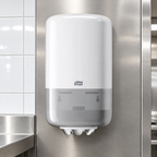 Hvid Tork M1 Mini 558000 centerrulledispenser i køkkenets serviceområde