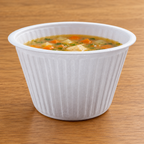 Hvid rillet XPS-termoskål med suppe på træbord