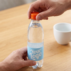 En hånd drejer det orange låg på 0,5-liters logovand ved en kaffepause
