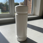 Hvid Kiehl refillflaske uden låg på sollyst arbejdsbord