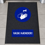 Smudsmåtte med Vask Hænder ved dør til venteværelse, genereret miljøbillede