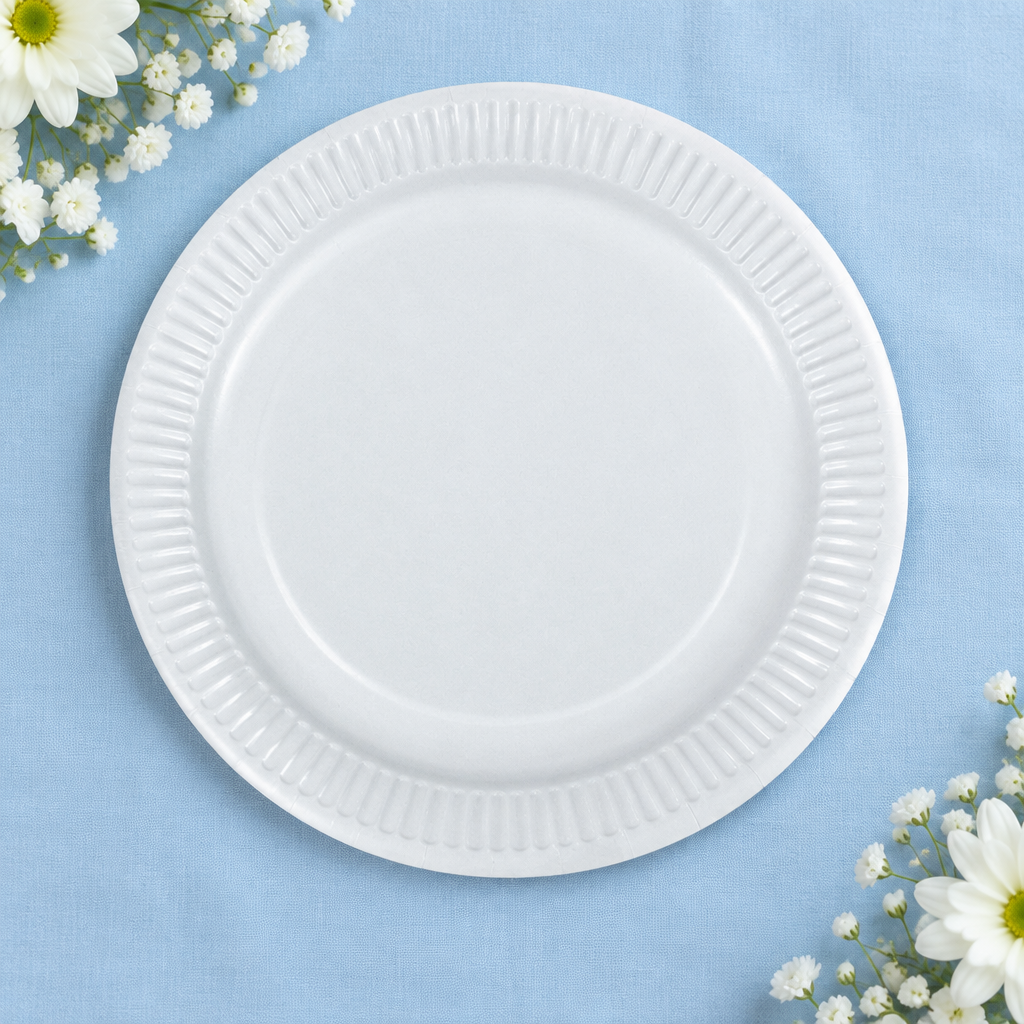 Hvid paptallerken på lyseblåt festbord med blomster