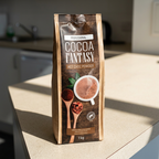 Cocoa Fantasy kakaopulver i pose på en solbeskinnet bordplade i kontorkøkken
