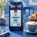 Gevalia 1853 mørkristede kaffebønner ved cappuccino på blåt morgenbord, stemningsbillede