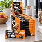 Stemningsillustration af Corny Protein Caramel Nougat displayæske ved kontorets snackstation