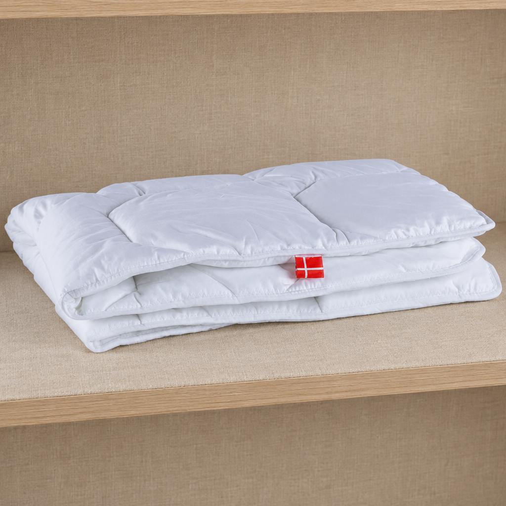 Foldet hvid babydyne på hylde med beige tekstil