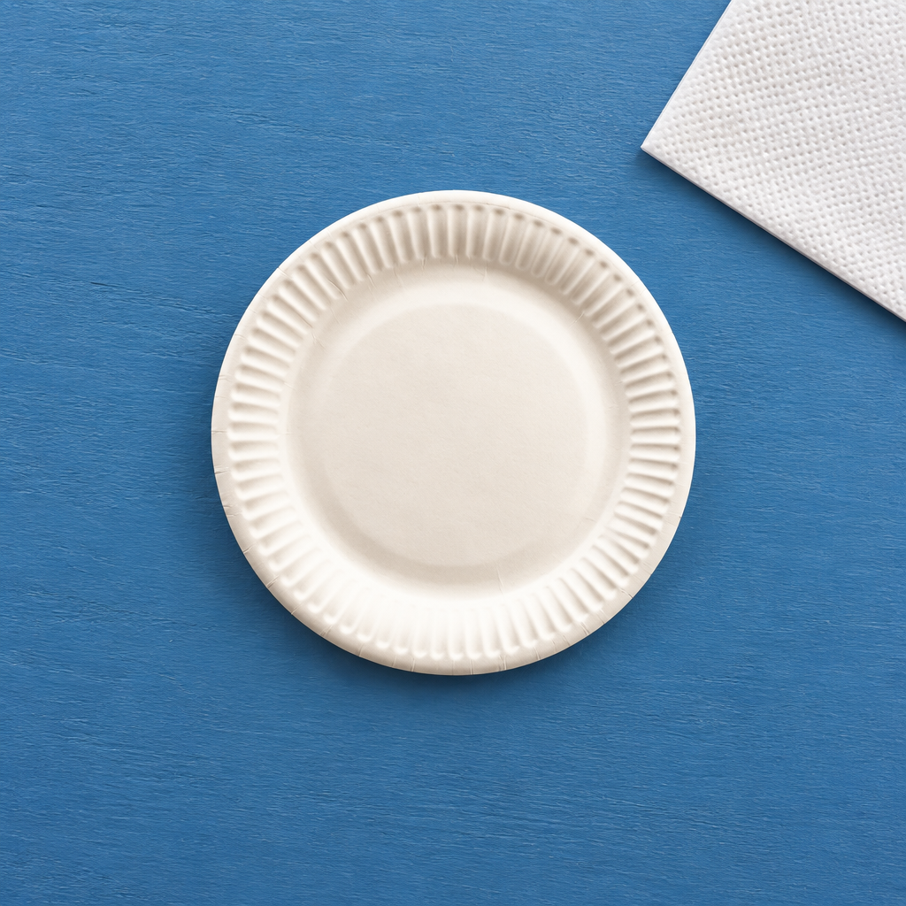 Hvid paptallerken på blåt bord ved hvid serviet