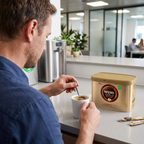 Kaffetilberedning set over skulderen med Nescafé Gold Blend 500 g ved koppen; øvrige serveringsvarer er ikke inkluderet