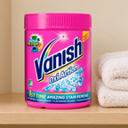 Pink Vanish-bøtte på beige hylde ved lyse håndklæder