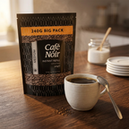 Café Noir Medium instant kaffe med kaffekop og teske på træbord