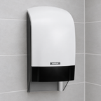 Katrin-toiletrulledispenser med hvid front og sort panel på grå fliser