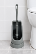 Grå toiletbørste med åben holder i lyst badeværelse, stemningsillustration