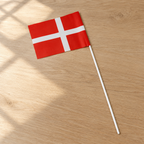 Dannebrog papirflag på 50 cm pind på et træbord