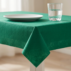 Detalje af grøn airlaid-dug ved bordkant med glas og tallerken