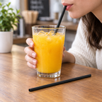 Sort lige sugerør på bord ved juiceglas og tilsvarende sugerør i brug