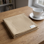 Foldet beige Micro Multi viskestykke ved kaffekop