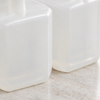Detalje af Kleenex-refillernes lyse plastbeholdere på en bordplade