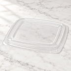 Transparent rektangulært plastlåg på lyst marmorbord