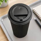Sort låg på Ripple-kaffebæger på bakke ved notesbog