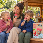 Voksen og to børn med Sun Lolly ØKO Hindbær i børnehavens have