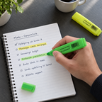 Grøn Q-Connect highlighter i brug til farvemarkering af en opgaveliste med en gul tusch ved siden af
