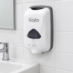 Hvid GOJO TFX-12 skumsæbedispenser på flisevæg ved håndvask