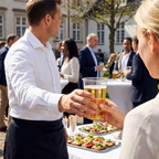 Servering af øl i klart plastglas ved en udendørs reception