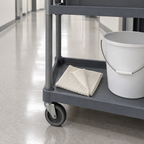 Ubleget gulvklud på nederste hylde af rengøringsvogn ved spand