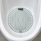 Urinalmåtte med parfume placeret i hvidt keramisk urinal