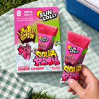 Sun Lolly Sour Pink-æske og åbnet is på mintgrønt picnictæppe
