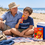 Barn og bedstefar med Sun Lolly Exotic ved strandpause på picnictæppe