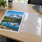 Stemningsbillede af blank lamineringslomme og stort ark på kontorbord