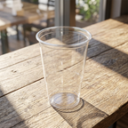 Tomt klart plastglas på et cafébord i sollys