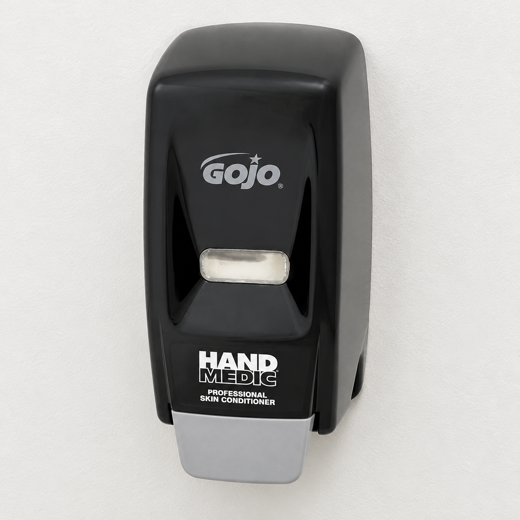Sort GOJO Hand Medic-dispenser på lys væg