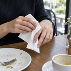 Hvid papirserviet i brug til aftørring af fingre på café, stemningsbillede