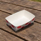 Pommes frites-bakke med rødt udvendigt tryk på picnicbord