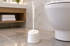 Hvid Basic-toiletbørste i hotelbadeværelse set fra lav vinkel, stemningsillustration